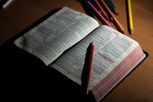 A bible lays open with a pen.
